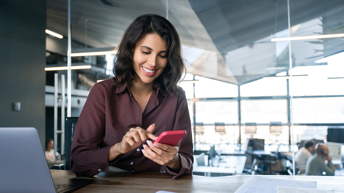 Frau im Büro nutzt auf ihrem Smartphone die Employee Experience Plattform Workvivo.
