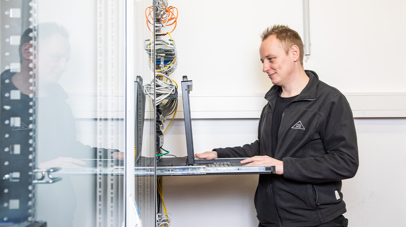 Ein Mitarbeiter der WTG Sicherheitssysteme steht an einem Pult.