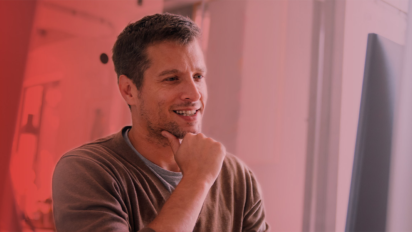 Ein Mann sitzt vor einem Rechner und freut sich über ITSM.