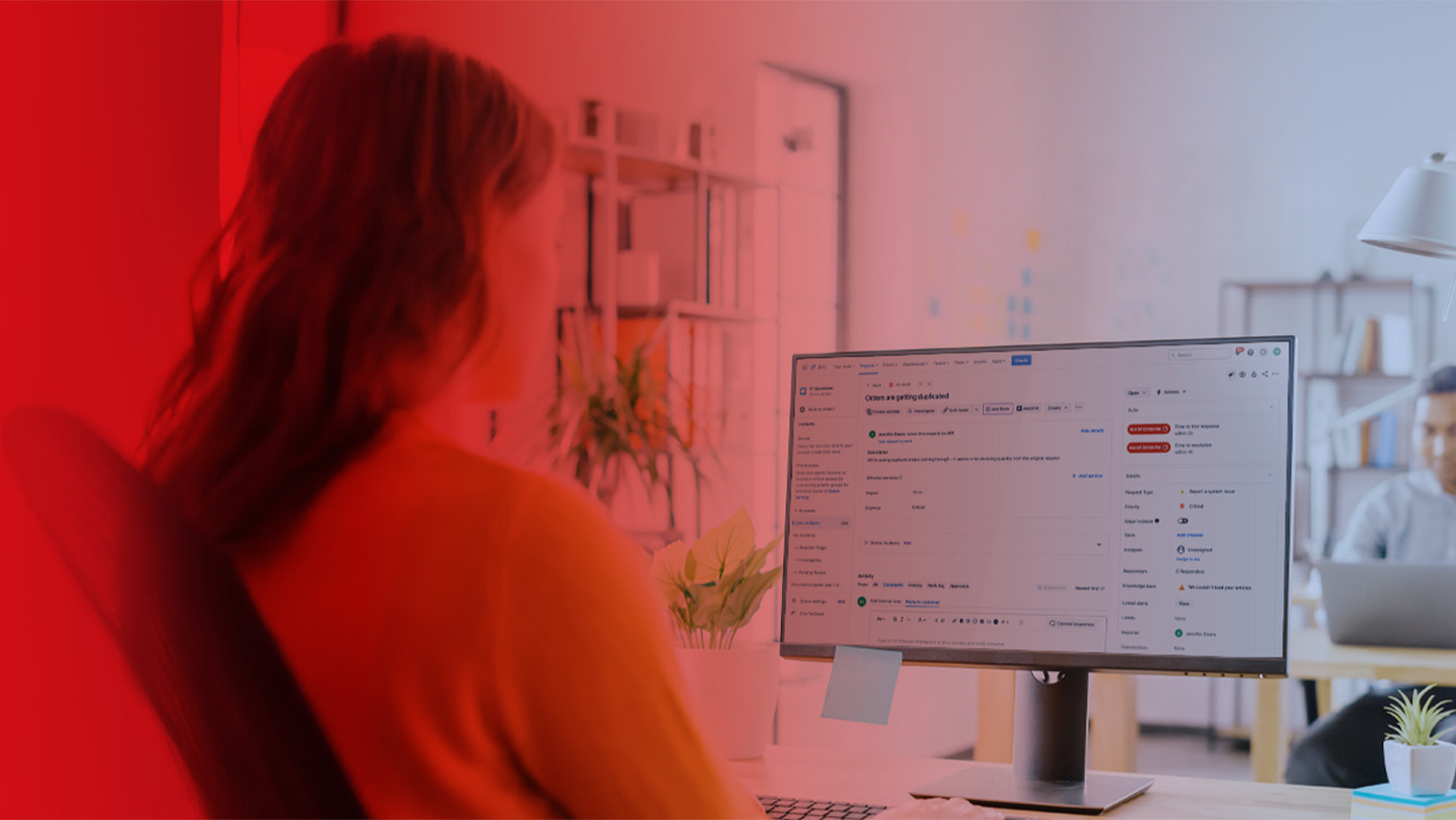 Eine Frau nutzt Jira Service Management an einem Rechner.