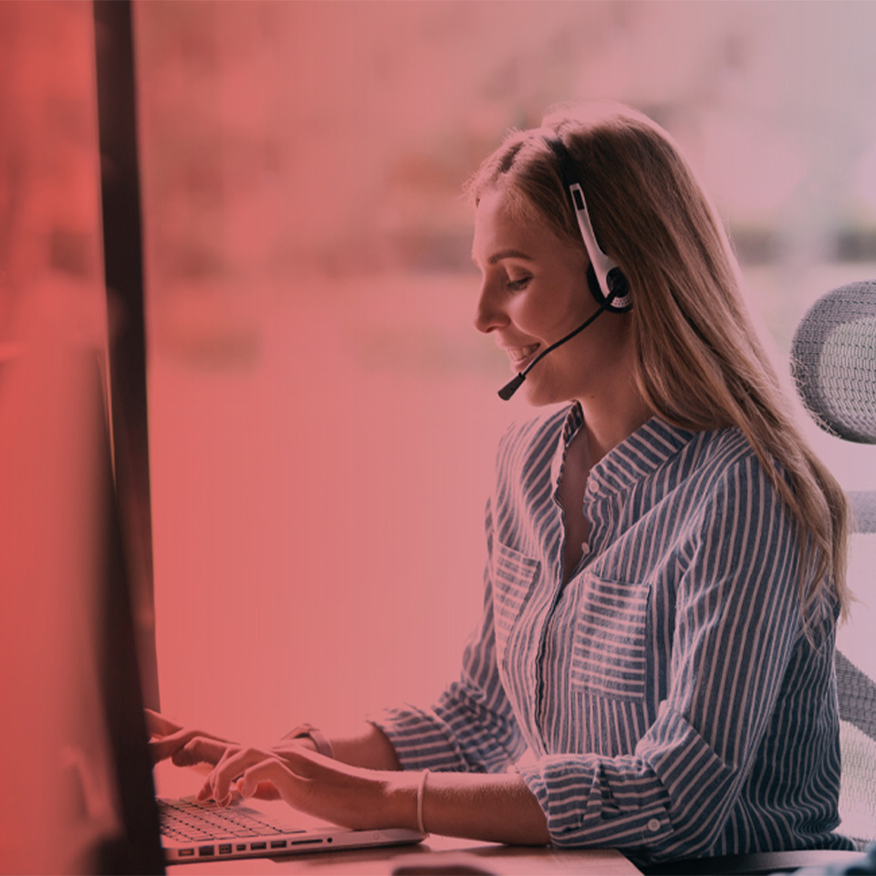  Zwei Personen mit Headsets arbeiten an Computern mit Avaya IP Office in einem Büro.
